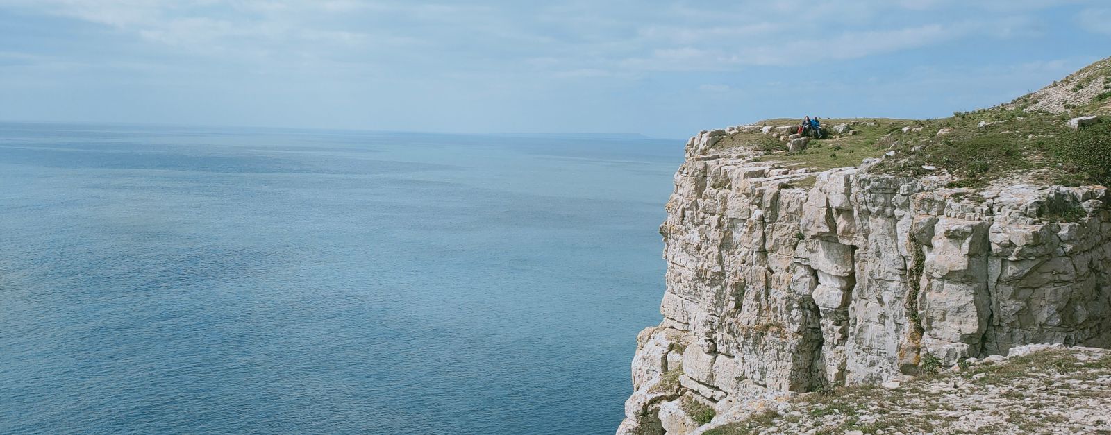 Breathtaking view of a rocky cliff beside the calm sea in England.