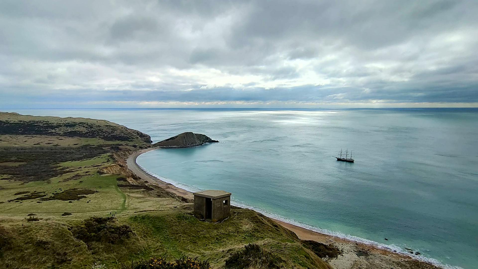 Breathtaking scenic view of the Jurassic Coast in England with a lone ship at sea.
