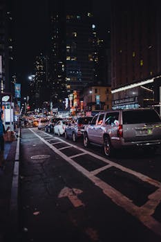 夜晚的城市街道上，停放的汽车和明亮的灯光让街道显得格外生动