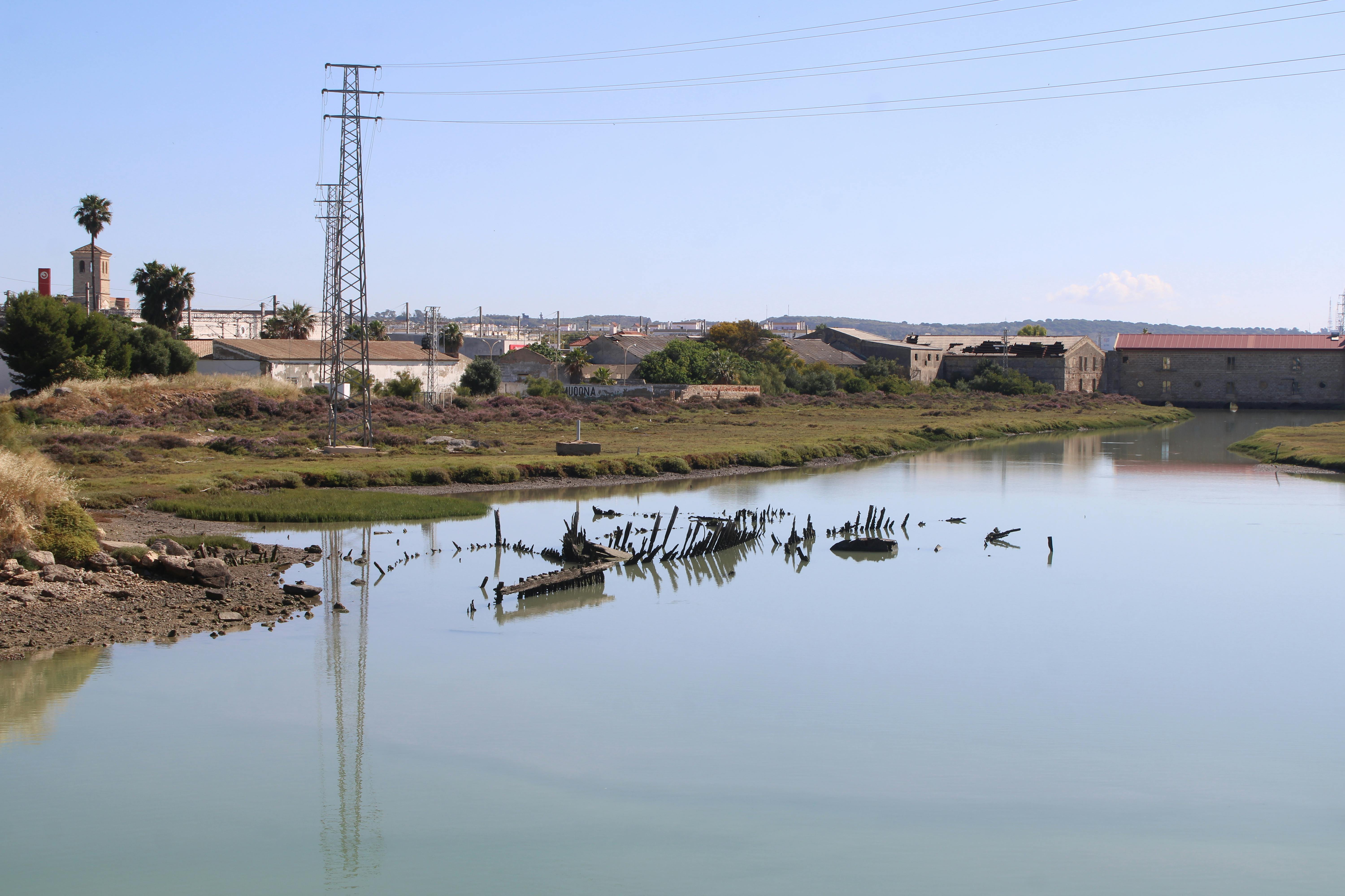 el antiguo molino de mareas de El Puerto contempla los restos de las barcazas semisumergidas