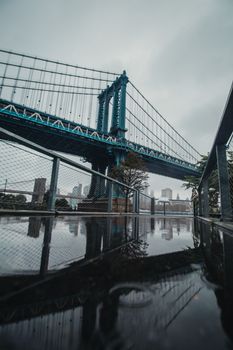 雨天，曼哈顿大桥的醒目景色与城市天际线的倒影交相辉映