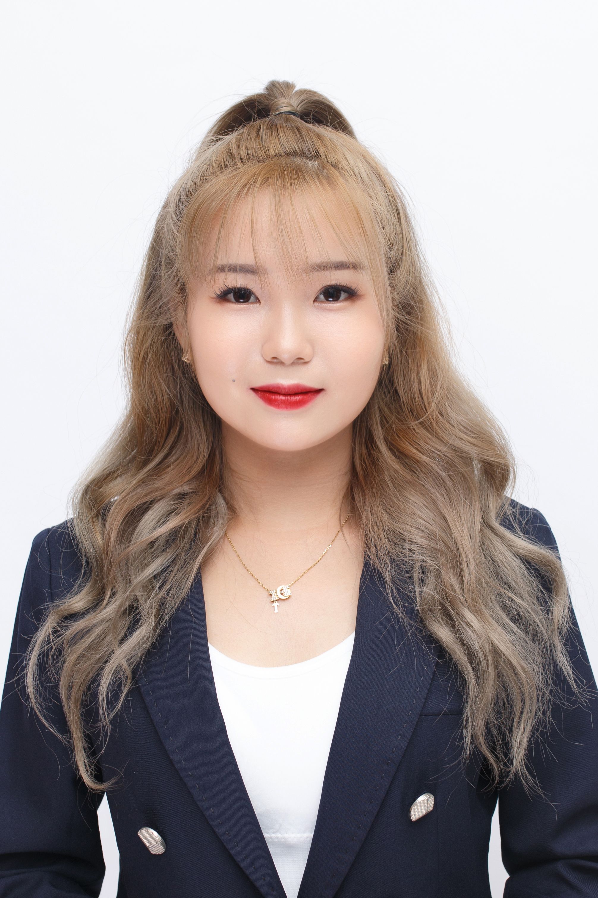 Chic portrait of a blonde woman in elegant business attire with a confident expression.