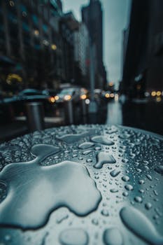 城市背景下的金属表面雨滴特写