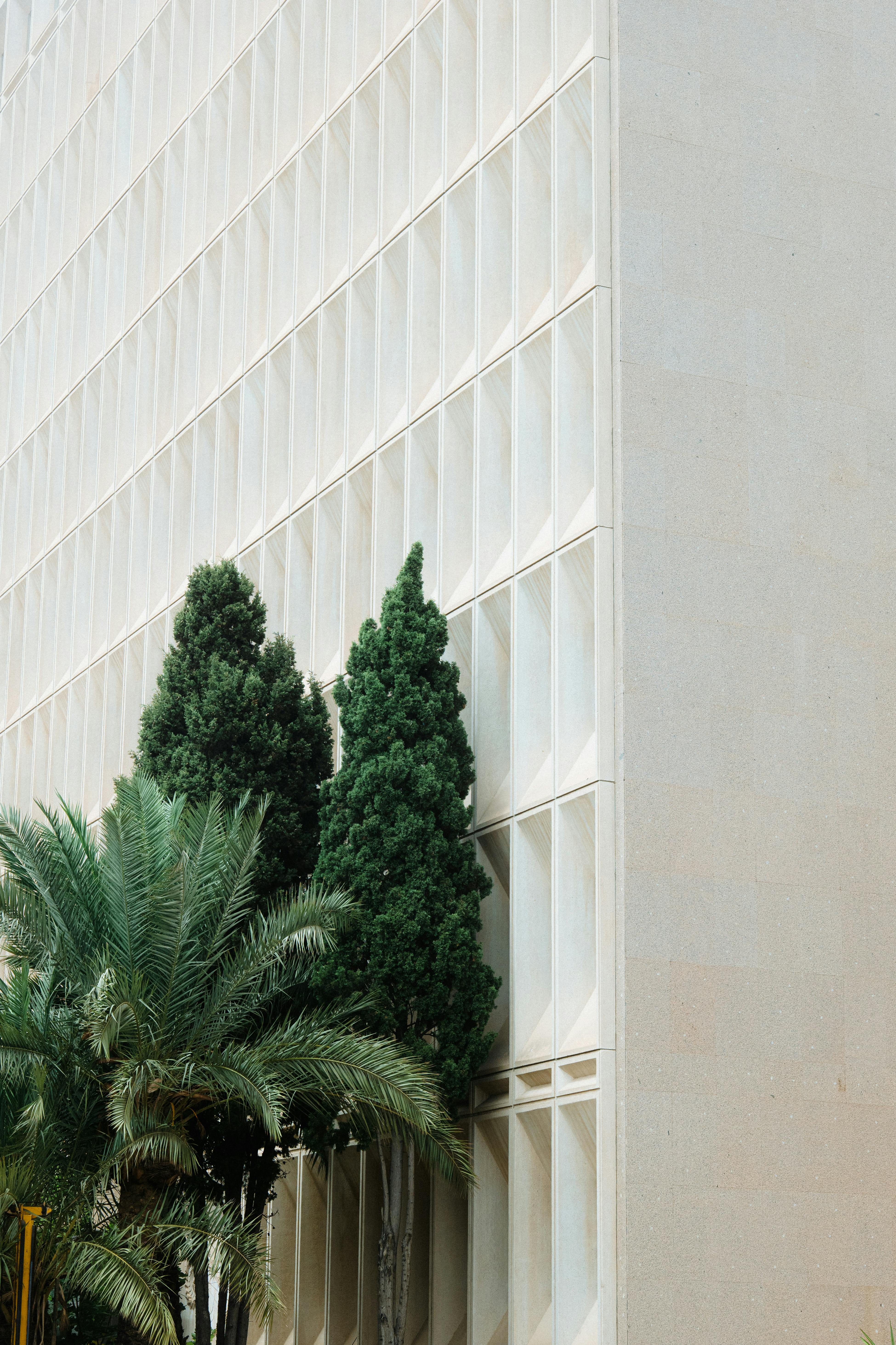 A modern building facade with trees and plants, capturing urban nature.