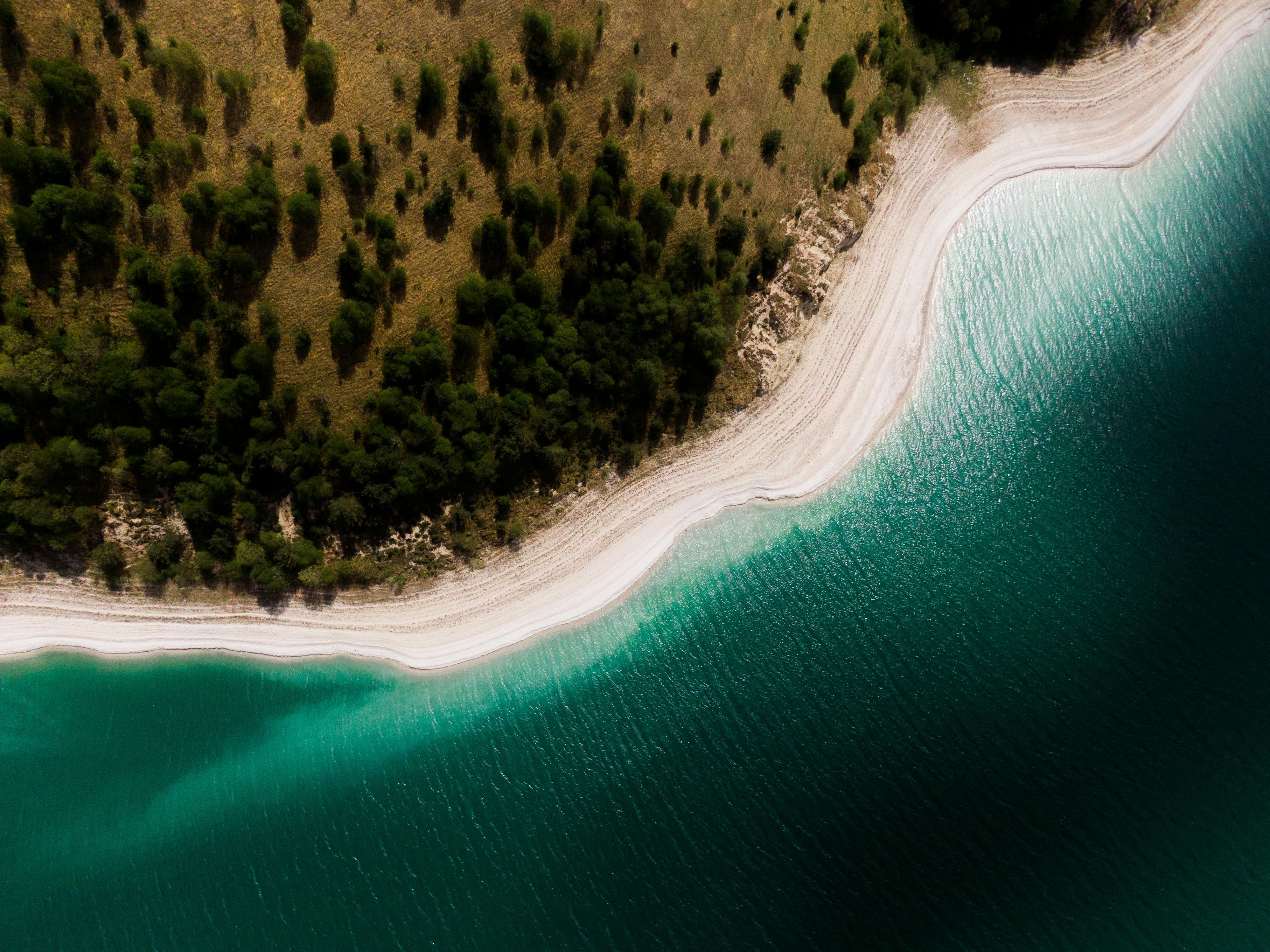 Stunning aerial view of a pristine beach with turquoise waters and lush greenery.