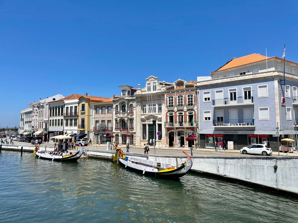 Bărci moliceiro colorate pe canalul din Aveiro, cu fațade ornamentate în fundal