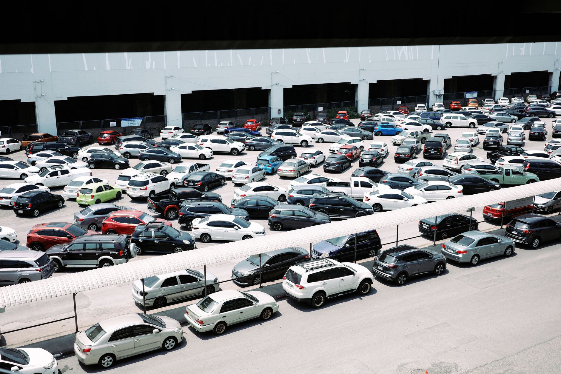 High-angle view of a crowded urban parking lot filled with various parked cars.