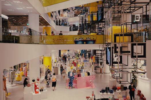 Vibrant mall filled with shoppers, contemporary decor, and stylish fashion outlets.