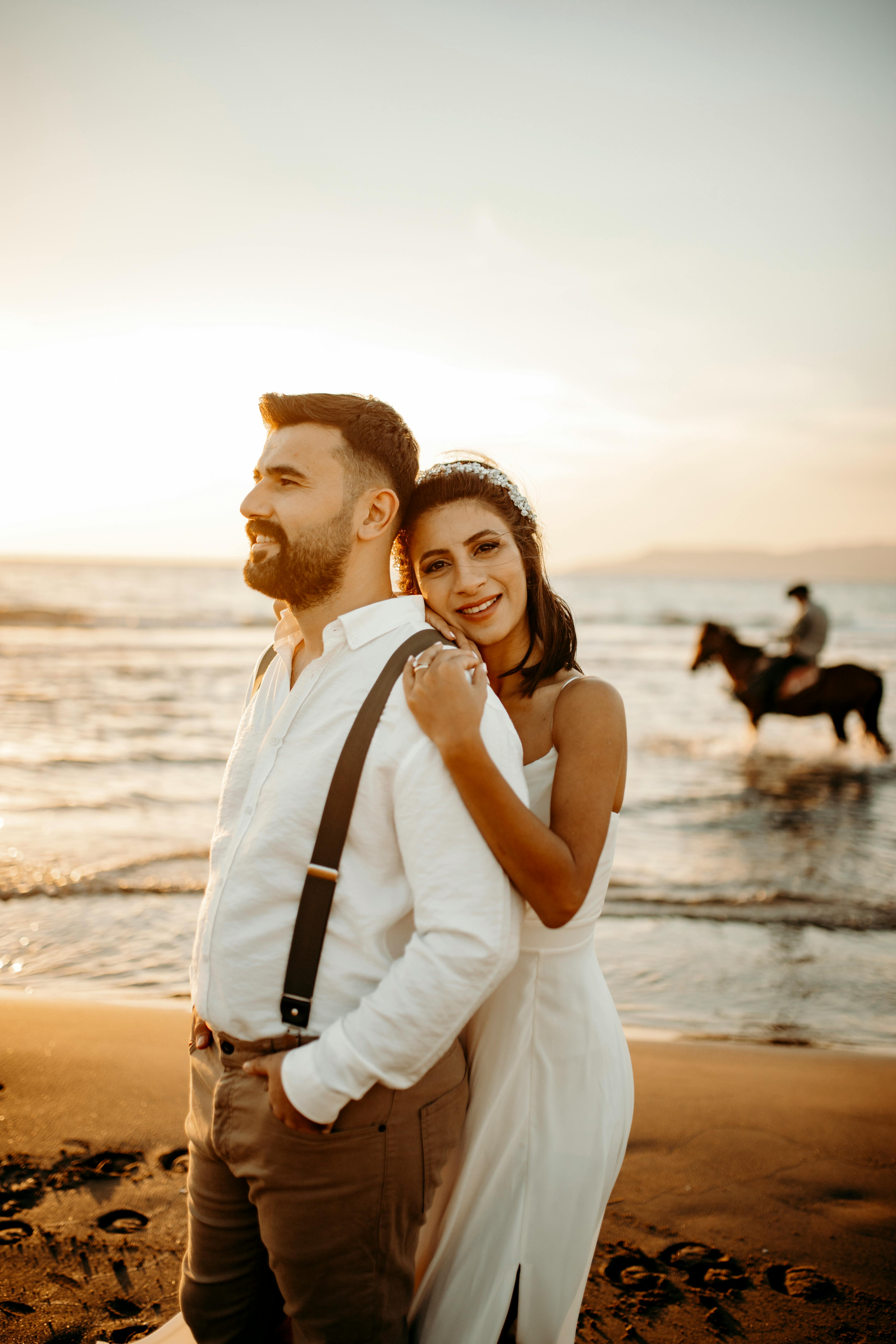 A couple enjoying a romantic moment on the beach in Selçuk, Türkiye during sunset.
