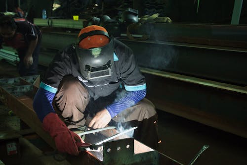 Man in Protective Clothes Welding in a Workshop 