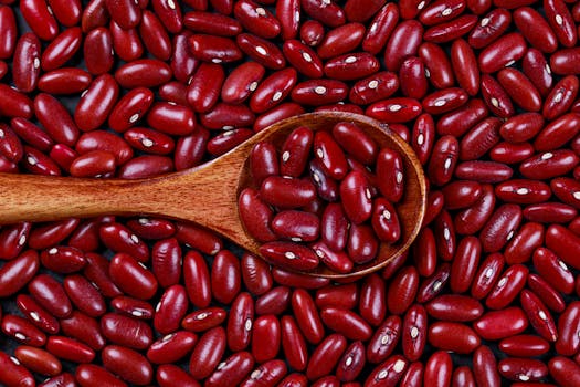 Close-up of red kidney beans and a wooden spoon, showcasing vibrant color and texture.