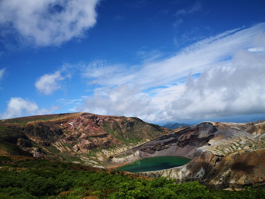 A beautiful mountain range with a serene lake under a clear blue sky.