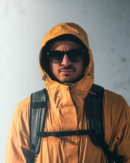 Free A stylish portrait of a man in a yellow jacket and sunglasses, suitable for outdoor fashion and lifestyle themes. Stock Photo