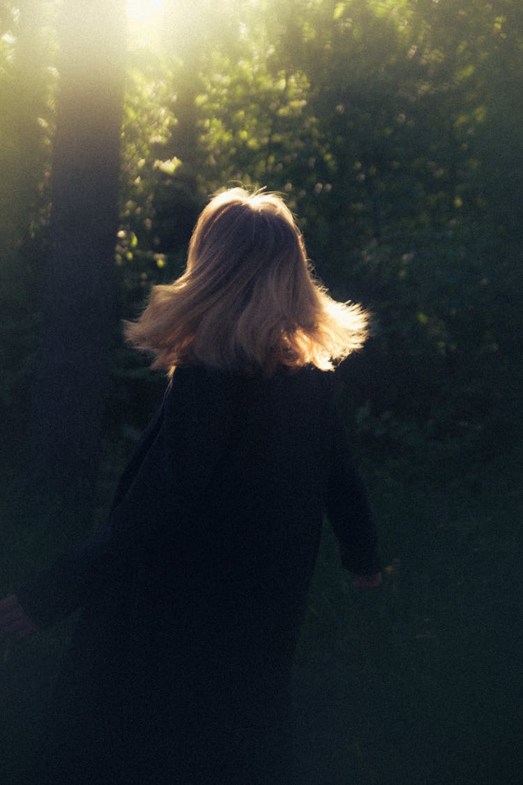 Blonde Woman Twirling In Sunlit Forest