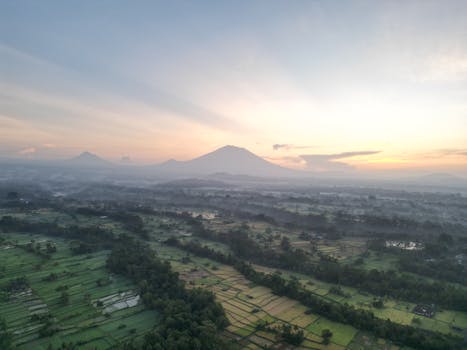 Stunning aerial view of rice fields and Mount Agung at sunrise in Gianyar, Bali, Indonesia.