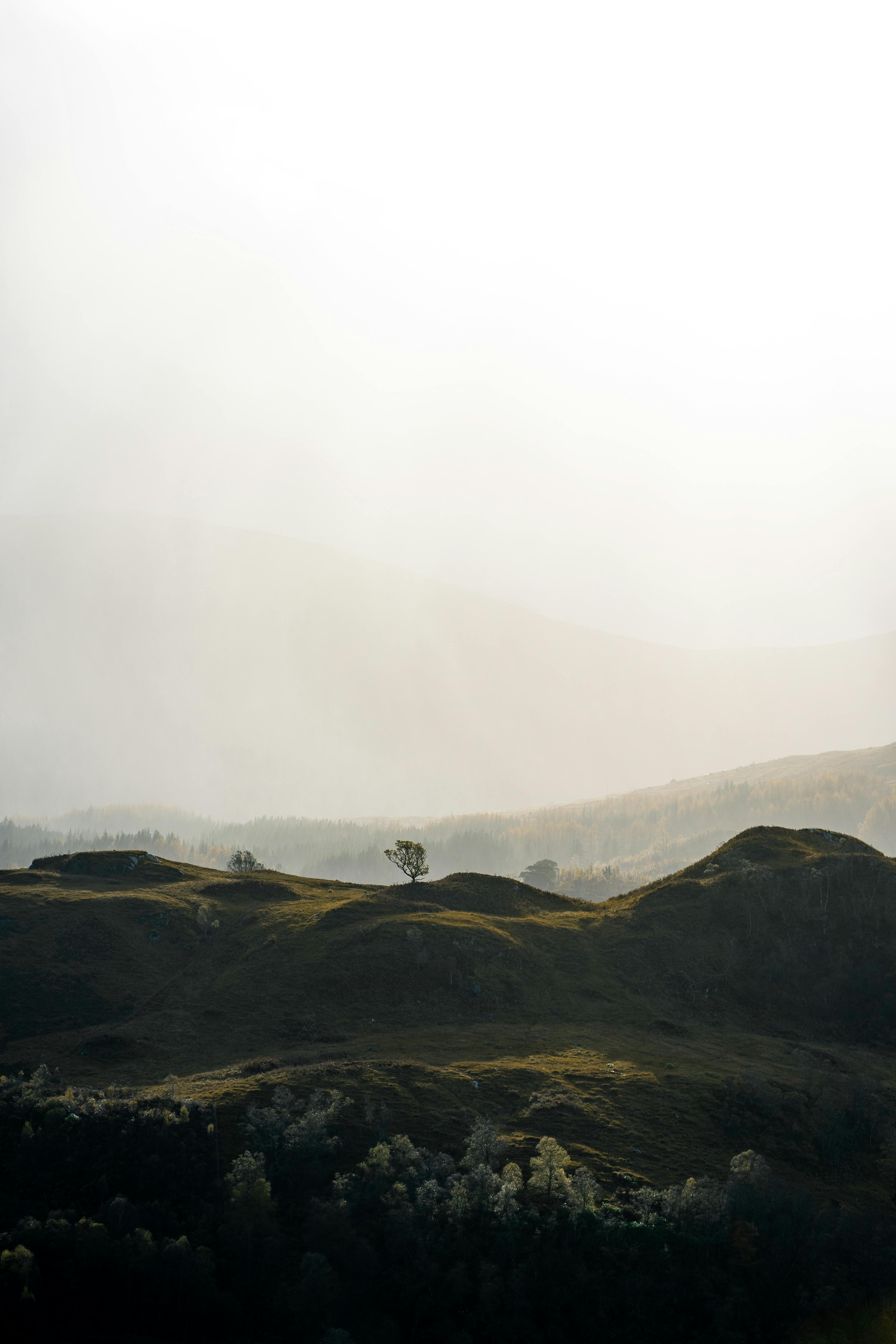 Serene Glenfinnan landscape with misty highlands and gentle hills under diffuse light.
