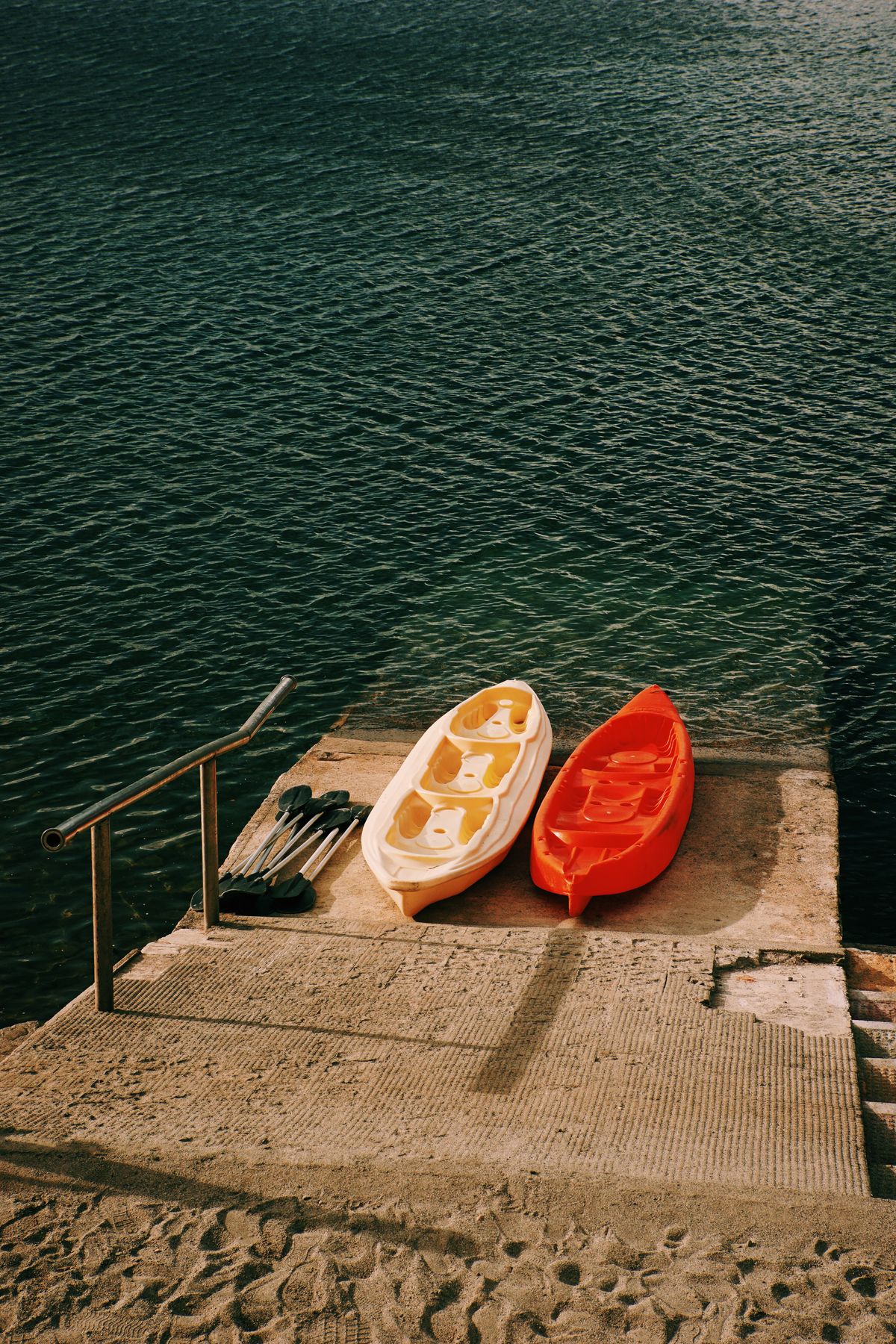 Kayaks and oars beside a boat slipway on a calm lake, the kind of lakeside launch setting found around Fruitport