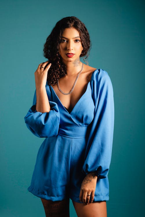 Young Brunette in a Blue Jumpsuit Posing in Studio 