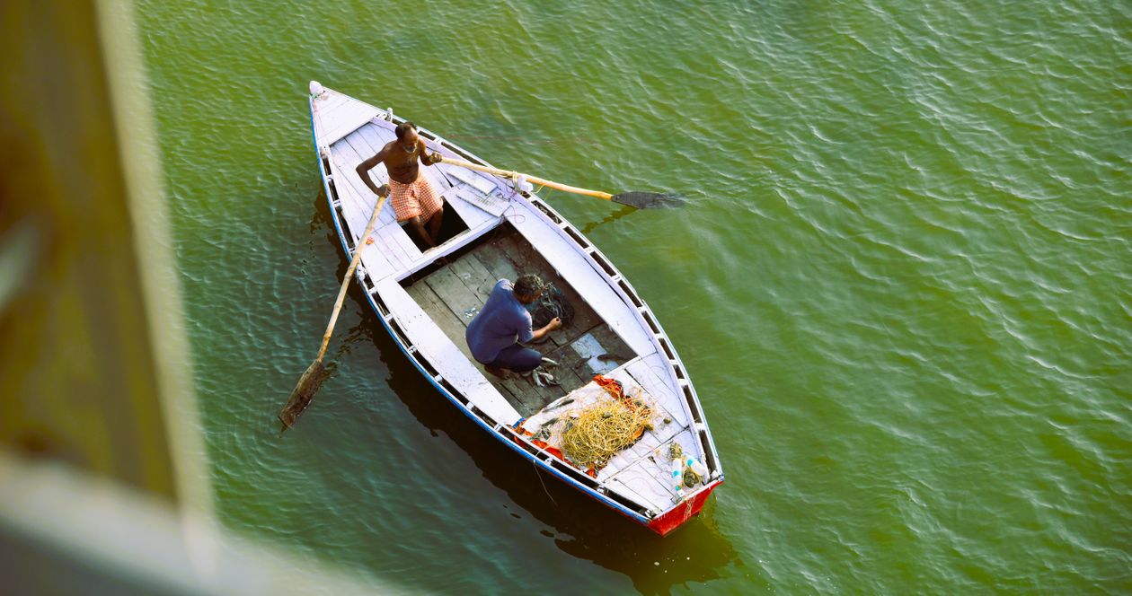 Two Men Fishing in Green Water on a Rowboat · Free Stock Photo