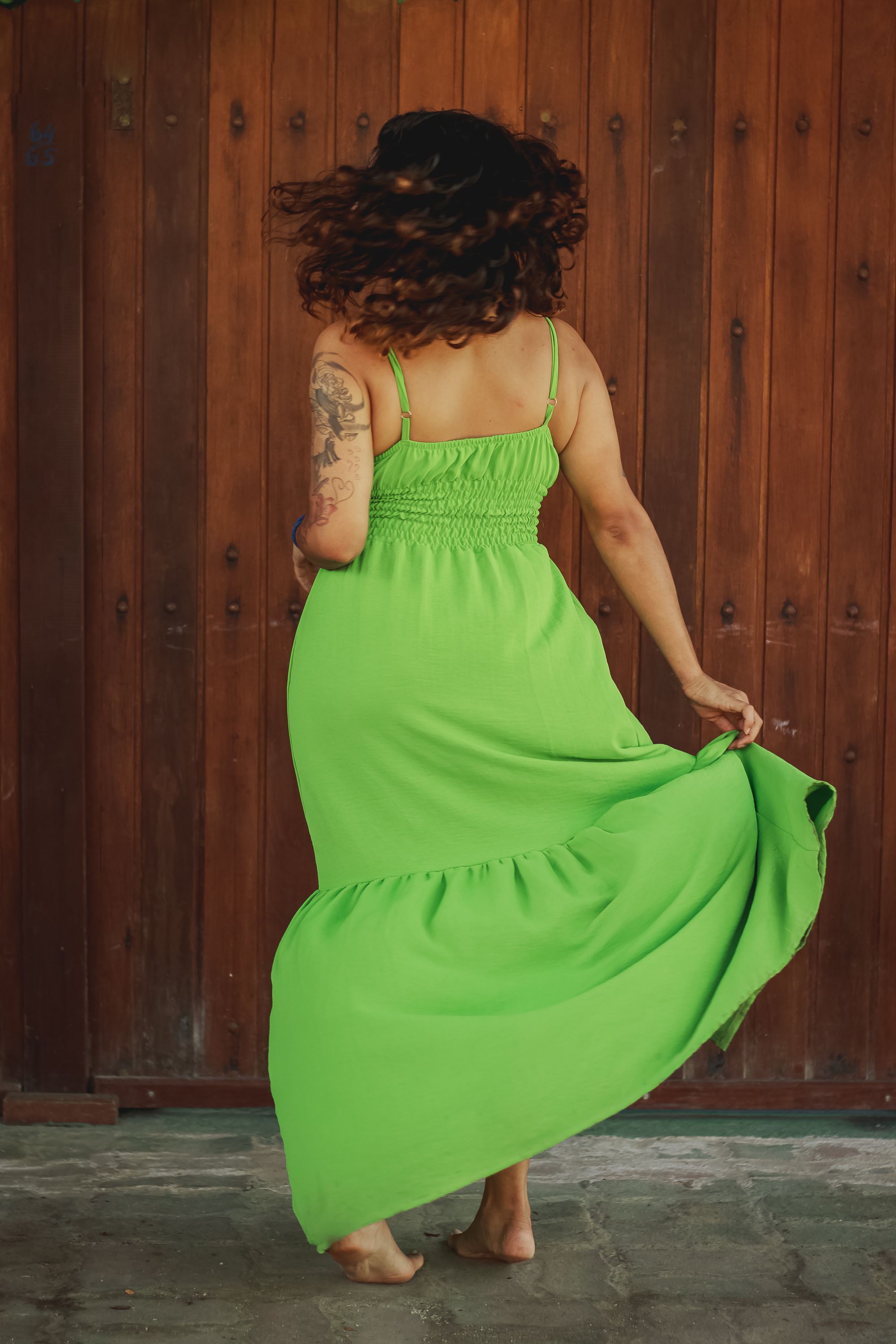 Back View of a Woman in a Long Green Dress Standing Outdoors Barefoot ...