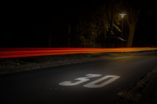 Free Time Lapse Photography of Red and Orange Light on Road With 30 Print on Nighttime Stock Photo