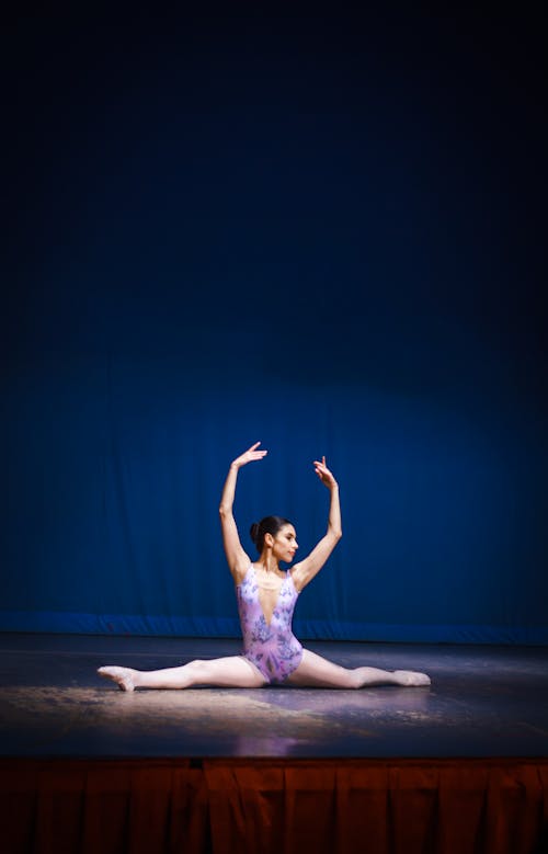 A Ballerina Doing the Splits on Stage 
