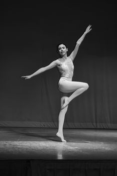Elegant ballerina performing on stage, captured in classic black and white photography.