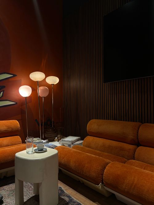 Free Cozy modern living room featuring orange velvet couches and standing lamps. Stock Photo