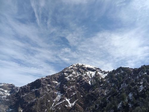 Free Capture of a rugged snow-covered mountain peak against a vibrant blue sky, showcasing nature's majesty. Stock Photo