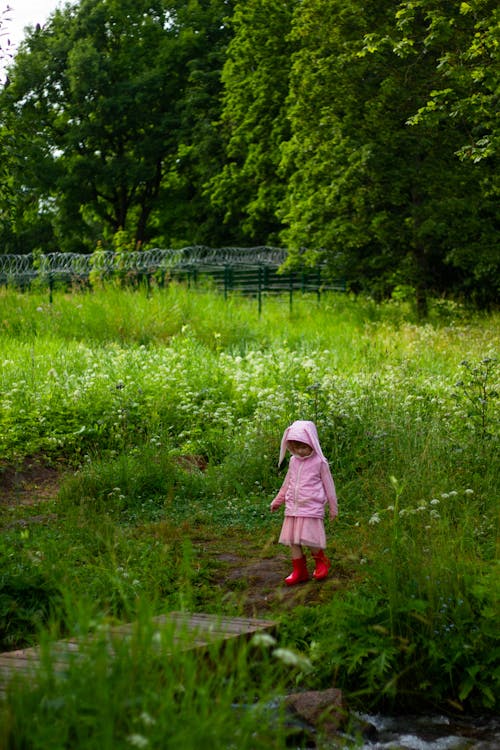 Girl Walking in Green Field in Summer