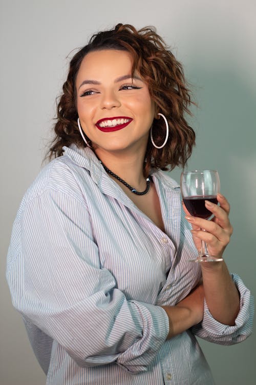 Young Woman in a Blue Shirt Holding a Glass of Red Wine 