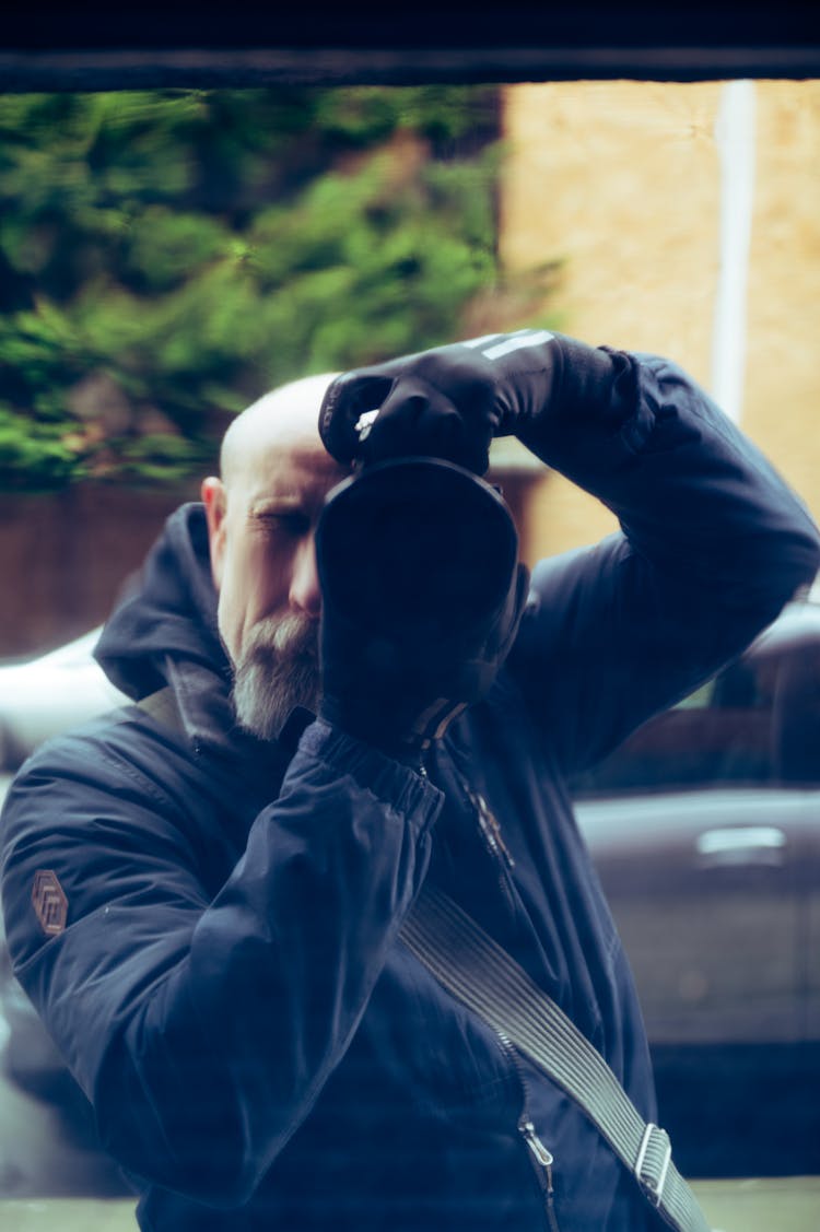 Old Bearded Man Taking Photo In Window Reflection