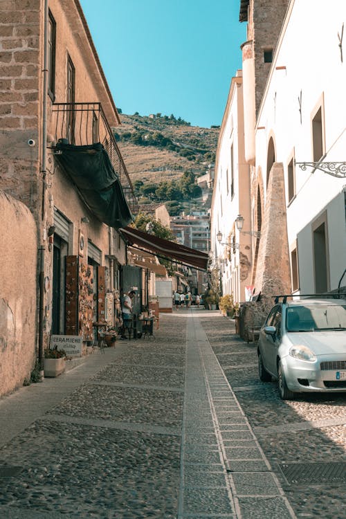 A Narrow Cobblestone Alley between Traditional Buildings in an Italian Town 