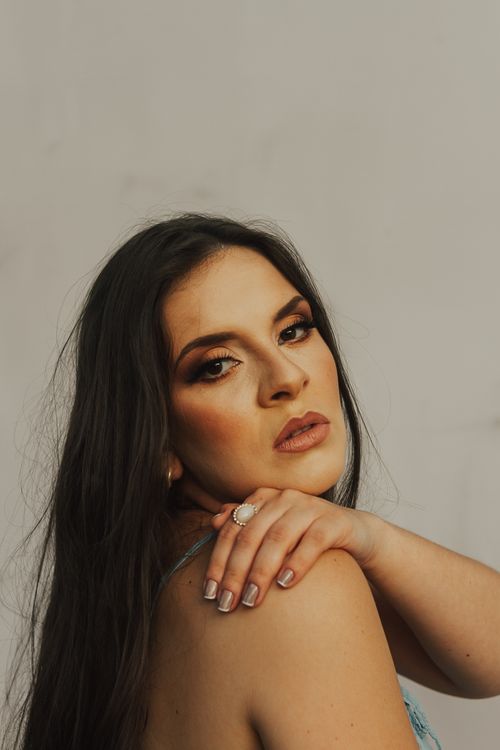 Free Elegant portrait of an adult woman with long hair and hand on shoulder Stock Photo