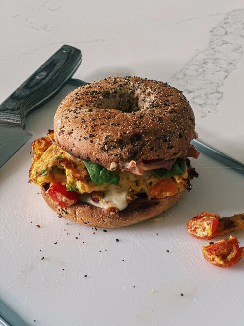 Free Mouth-watering bagel sandwich with fresh veggies and cheese in Atlanta kitchen. Stock Photo