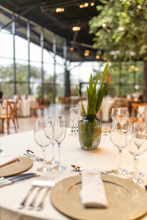 Crystal Vase with Leaves on a Table in Restaurant