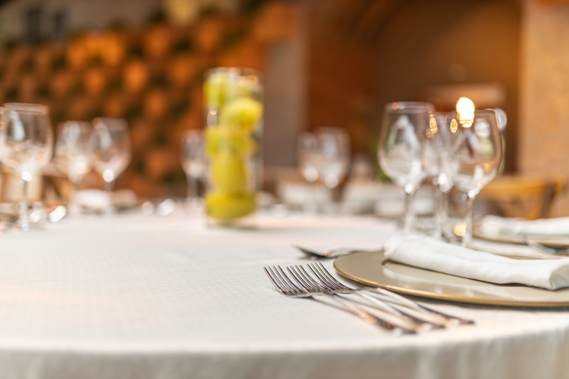 A close-up of a modern restaurant table setting featuring glassware and cutlery.