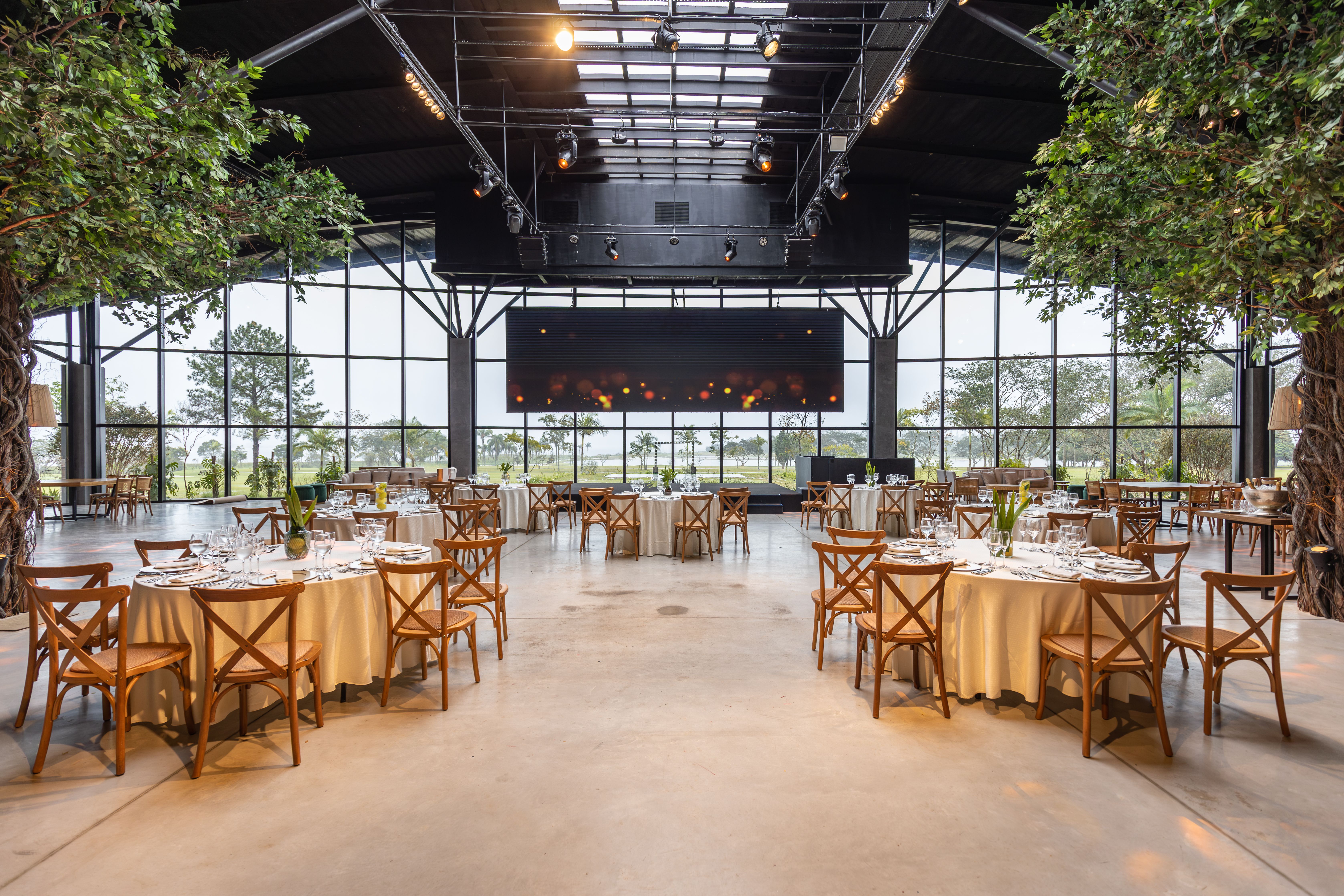 Spacious and elegant indoor venue with round tables set for a banquet or celebration.