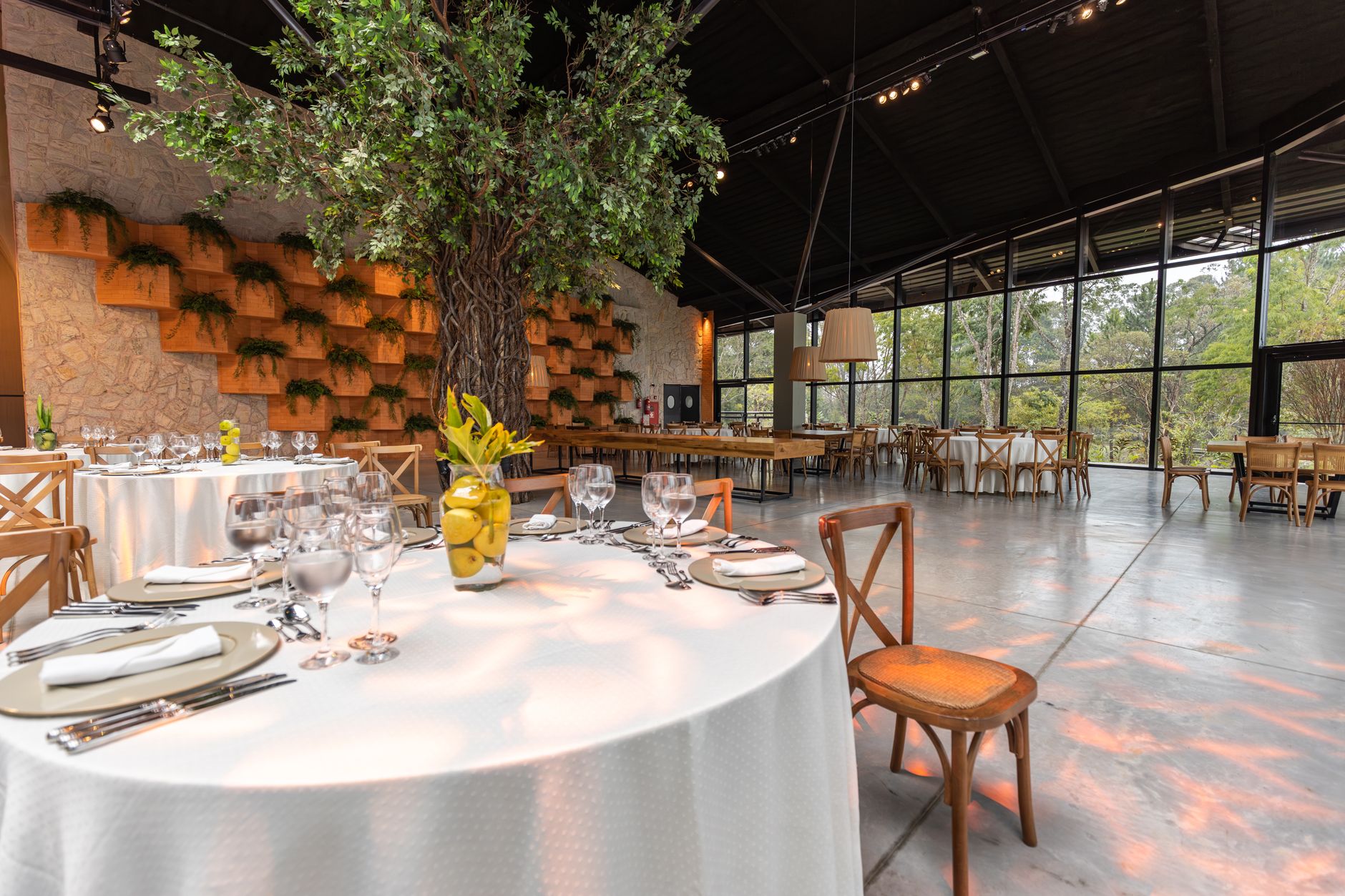 Elegant modern dining area with large windows, natural decor, and a stylish table setting.