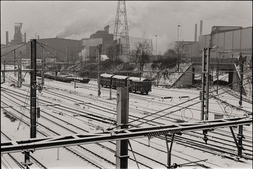 Free Black and white photo of snow-covered railway tracks in an industrial area during winter. Stock Photo