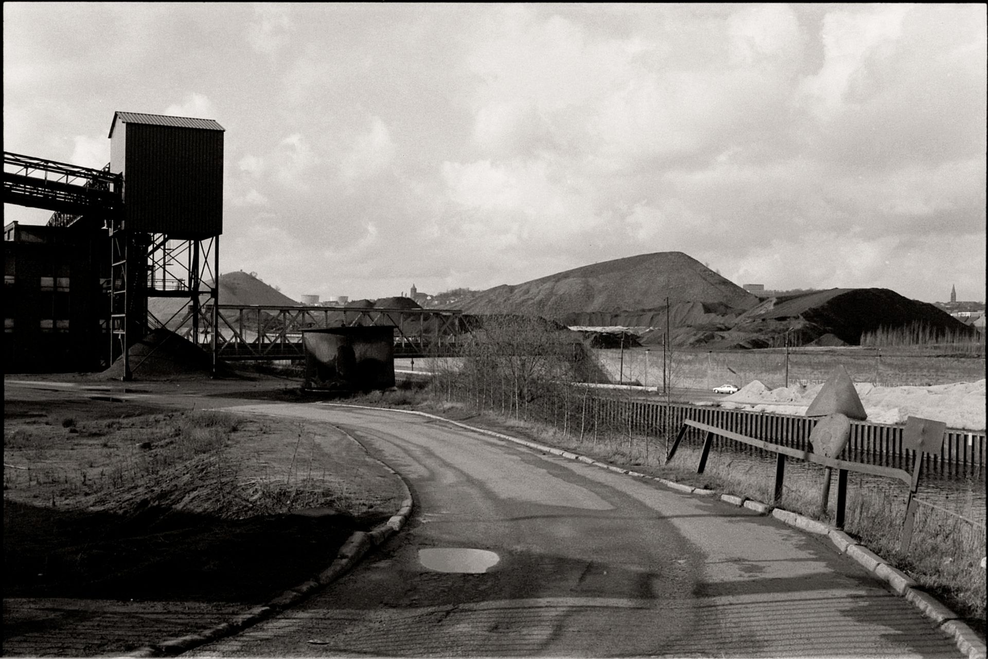 An industrial coal stockpile under an overcast sky.