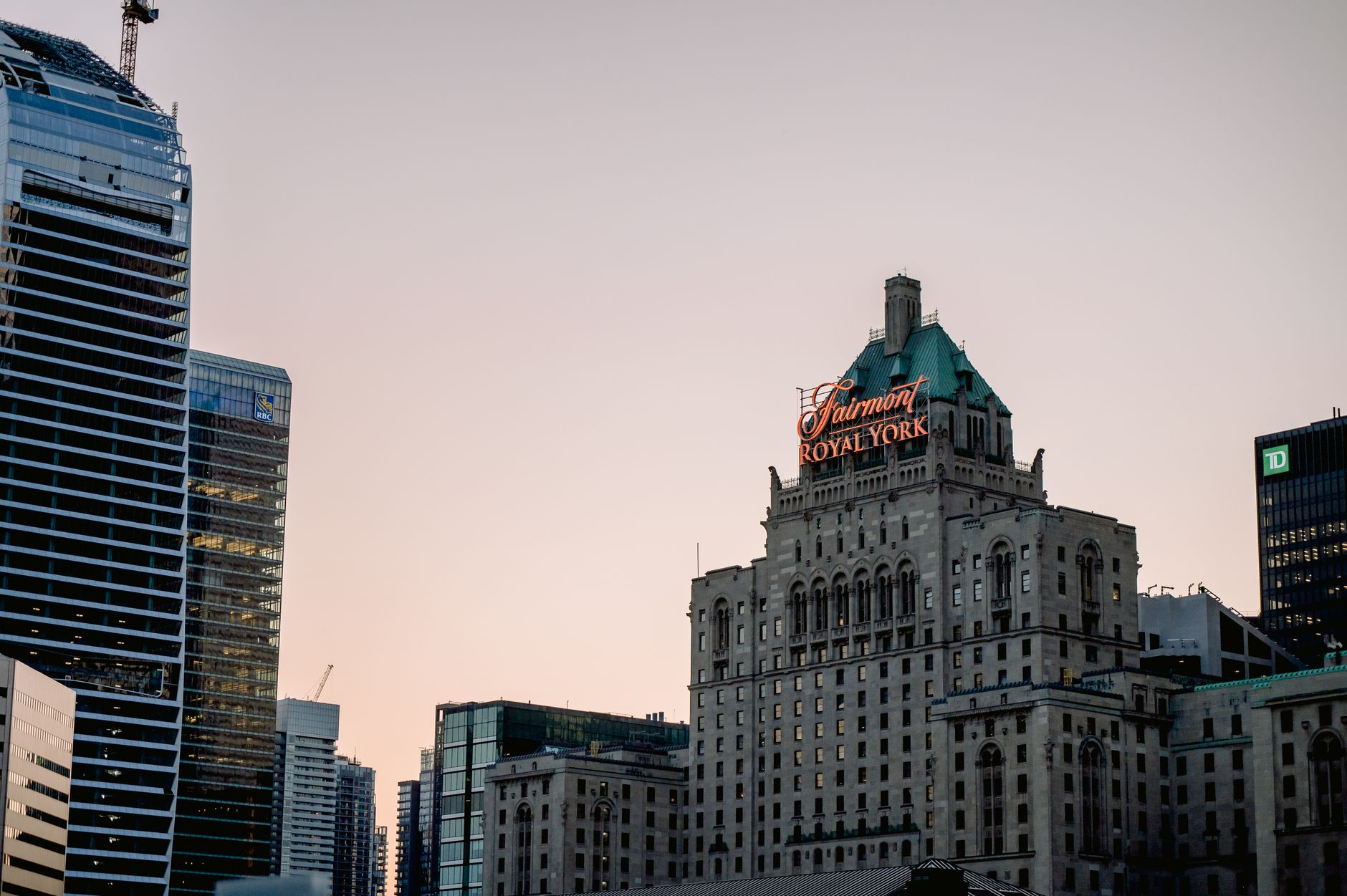 Iconic Fairmont Royal York hotel among modern skyscrapers at dusk in Toronto. Related image for Hospitality in Canada: How Technology Is Reshaping Strategy.