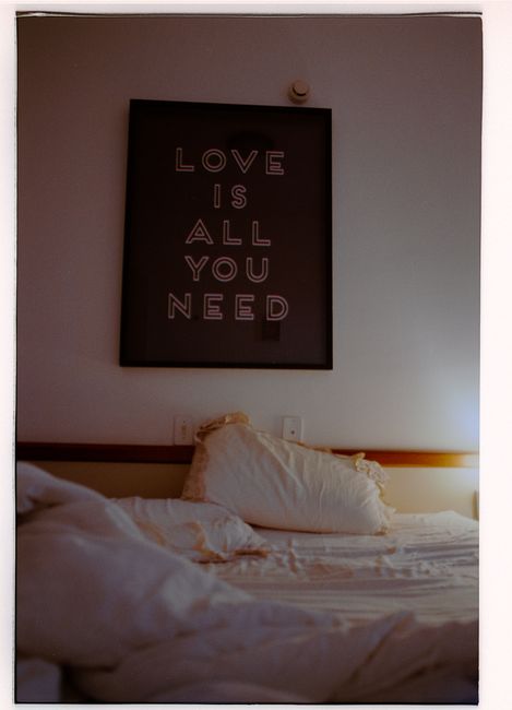 A serene bedroom featuring a bed and an inspirational wall art above it.