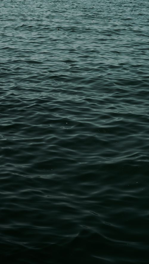 Free Calm sea waves creating a reflective surface in a tranquil, abstract composition. Stock Photo