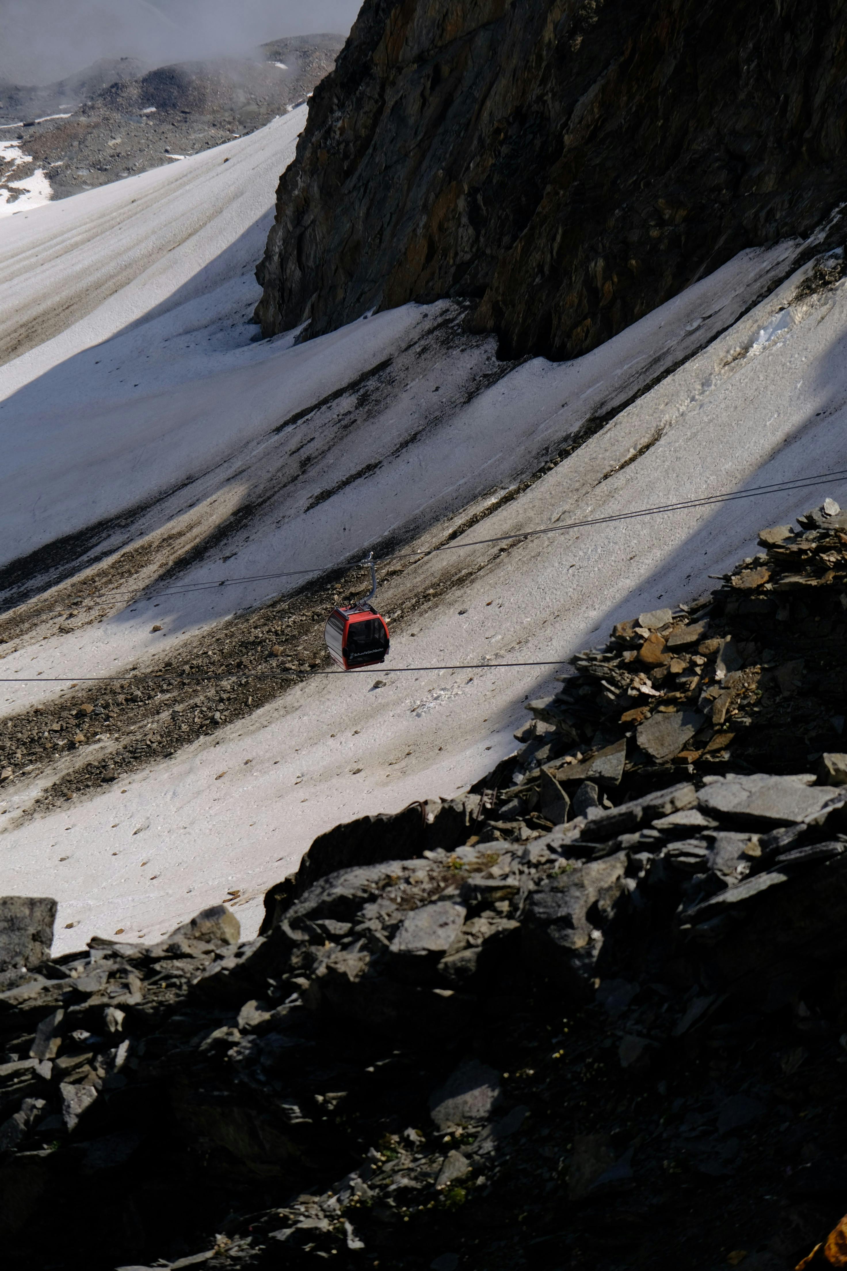 Prescription Goggle Inserts - Red cable car moving up a snowy mountain slope, perfect for winter sports and travel theme.