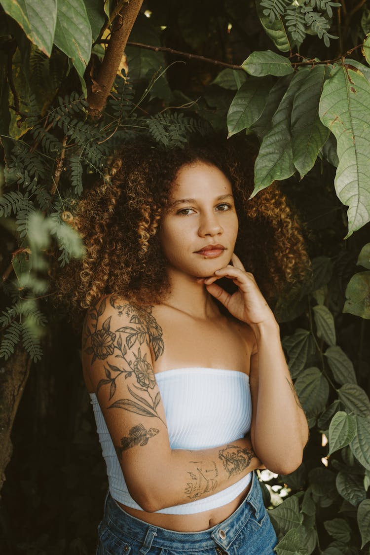 Young Woman With Tattoos Posing Outdoors In Summer