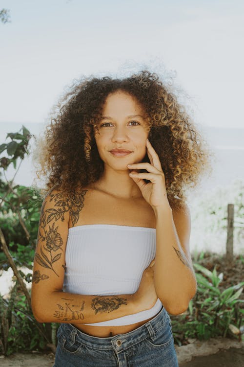 Young Woman with Tattoos Posing Outdoors in Summer