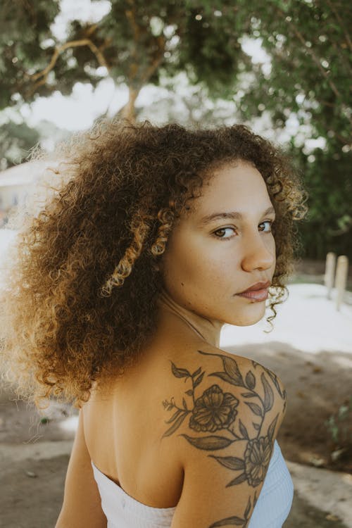 Young Woman with Tattoos Posing Outdoors in Summer