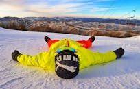 在晴朗蓝天的滑雪胜地，身着活力冬装的人们正在雪山上放松