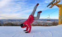 一个穿着红色外套的男人在雪山上倒立着欣赏风景